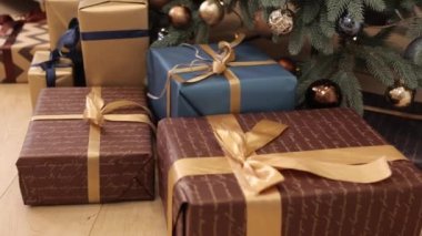 Tatil hazırlıkları, yeni yıl hediyesi, Noel ağacı. Birçok Noel hediyesi kutusu kurdele ve süslemelerle birbirine bağlanır, Noel arkaplanı görülür, güzel Noel hediye kutuları
