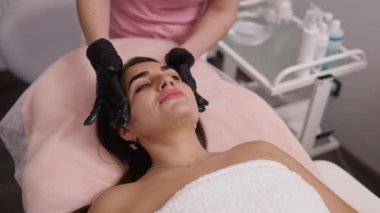 Yüz derisi, eldivenli doktor, kozmetoloji kliniği. Kozmetoloji kliniğindeki kadın hasta, kozmetoloji kliniğinde güzellik prosedürleri uygulayan doktor, hastanın cildiyle ilgilenen, güzellik uzmanı...