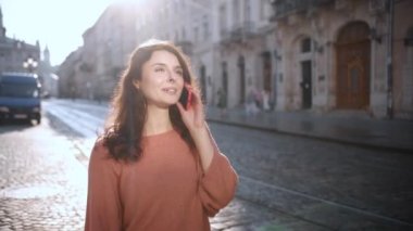 Konuşan telefon, kıvırcık saç, akıllı telefon kullanan, yürürken telefonla konuşan, kıvırcık saçlı neşeli Amerikalı kız, dışarıda telefonla konuşan güzel kadın, portre.