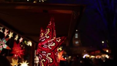 Noel yıldızı, Noel ışıkları, market, ön planda asılı duran Noel yıldızı. Ampullerle, Noel xmas aydınlatmalarıyla birlikte açık hava tatili.