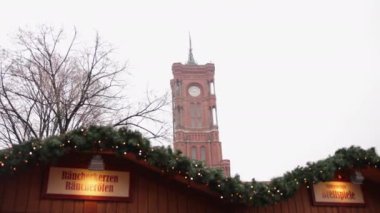 Berlin 'de bir bina, Rotes Rathaus, yarı gotik. Önplanda Berlins Mitte bölgesinde yer alan Red Town Hall, Rotes Rathaus 'un arkasındaki Noel süslemeleri olan dükkanlar.