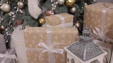 Noel kutlaması, yeni yıl hediyesi, Noel hediyesi. Noel hediye kutuları, kurdele ve süslemelerle bağlanmış, Noel arkaplanı, odada bir köknar ağacının yanında yerde duran güzel Noel hediye kutuları.