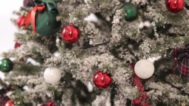 Noel oyuncakları, yeni yıl tatili, renkli ışıklar. Şenlikli Noel ağacı bulanık bir arka plana karşı duruyor, ağacı süsleyen bir tel bokeh çelengi kaplıyor.