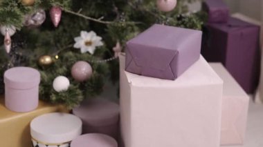 Hediye kutuları, köknar ağacı, tatil hazırlıkları. Kurdelelerle bağlanmış ve arka planda Noel süsleriyle süslenmiş bir sürü hediye kutusu, yerde güzel Noel hediyeleri kutuları.