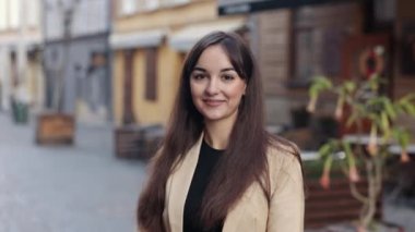 Yüz resmi, doğal makyaj, kendine güvenen bir iş kadını. Portre, sıradan bir ortamda genç bir kadının, güzel bir beyaz kadın portresi olan açık havada pozu.