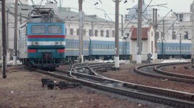 Tren istasyonunda bir yolcu elektrikli treniyle lokomotif. Demiryolu ile hareket eden eski bir lokomotif.