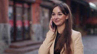 Dışarıda çalış, akıllı telefon kullan, kadın yürüyüşü yap. Dost canlısı bir bayan, şehirde yürürken sohbet ediyor, güzel bir kadın turist akıllı telefonunu kullanarak sokaklarda dolaşıyor.