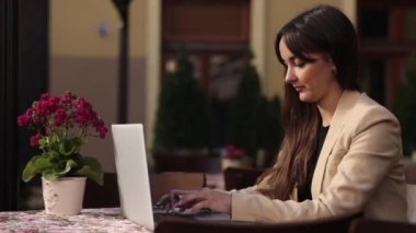 İş kadını daktilo, kadın çalışıyor, internette sohbet ediyor. İş kadını dışarıda dizüstü bilgisayarda yazıyor, klavyede çalışıyor, güzel esmer, dizüstü bilgisayarına e-posta yazıyor, blog yazıyor.