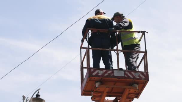 工人修理 电气技术 工人在高处修理路灯 更换路灯杆上的铅球 男子在电梯桶中戴个人防护装置 — 图库视频影像