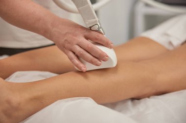 Aşırı kilolu dövüşme, tekerlekli masaj, donanım düzeltmesi. Profesyonel güzellik kliniği, güzellik hizmeti veren genç bir kadın, vücut şekillendirme, masör müşteriye süpürge masajı yapıyor, figür düzeltme.