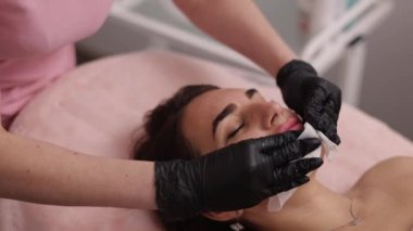 Güzellik prosedürü, temiz yüz, temiz cilt. Kozmetoloji kliniğinde kadın hasta, kozmetoloji kliniğinde doktor güzellik prosedürü uyguluyor, güzellik uzmanı hastaların yüzünü temizliyor.