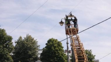 pole lamp, Technician on aerial, worker repair. Equipment installs, aerial device, Street light. Employee performs street light repair work on street lamp from height, replaces led lights of lamp