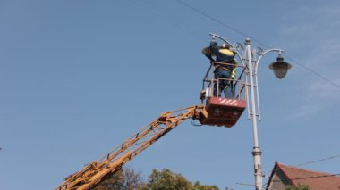 light bulb, pole lamp, equipment installs. Street light repair work, where workers repairing light pole lamp at height, replacing led lights, fixing street lights.