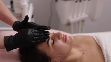 face area, cooling contact gel, Laser Treatment. Cosmetologist working in cosmetology clinic applying gel on face of woman before epilation, hair removal laser