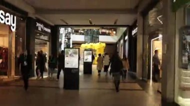 LVIV, UKRAINE - JAN 11, 2023: Customers buying, shopping mall, Time-Lapse. People crowded in shopping mall, high speed motion through corridor in modern shopping mall, hyperlapse timelapse of people