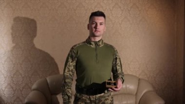 Nişan yüzüğü, askeri teklif, düşük taahhüdü. Bir asker evlilik yüzüklerini elinde tutuyor ve evlenme teklif etmeye hazırlanıyor..