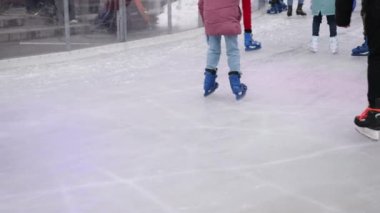 ice skating, details legs, Close up. During cold winter season, people ice skate on ice rink, having fun, vacationing, visiting Christmas market at Berlin Winter Garden.