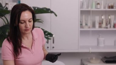 Spatül, epilasyon jeli, kadın yüzü. Estetisyen kadın derisini kozmetoloji kliniğinde lazer tüy temizleme tedavisine hazırlıyor. Güzellik uzmanı kadınlara epilasyon lazeri tedavisi uyguluyor.