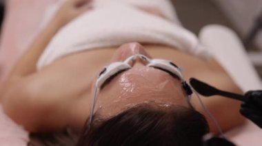 Lazer epilasyonu, berrak jel, kadın derisi. Kozmetik uzmanı kadın yüzüne epilasyon öncesi ultrason jeli uyguluyor, Esthetisyen kadın derisini lazer tüy aldırmaya hazırlıyor, Güzellik epilasyonu lazeri.