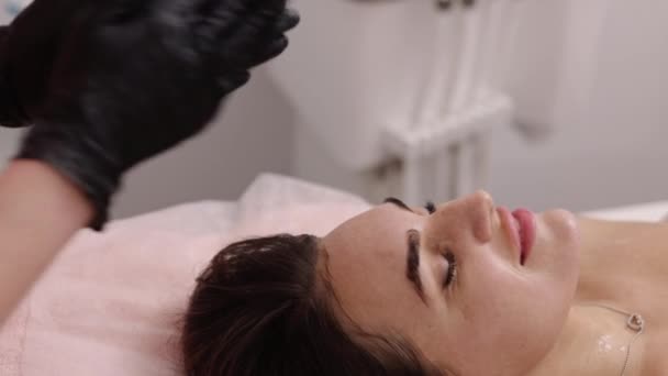 Gezichtsmassage Cosmetische Crème Gezichtsbehandeling Cosmetoloog Masseert Patiënten Gezicht Terwijl Wrijven — Stockvideo