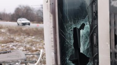 Kamyon kazası, araç denetimi, kırık camlar. Bir kamyon kazası ön camın kırılmasına neden oldu ve araç şu an arka planda polis arabasıyla yol kenarında, ışıklar yanıp sönüyor..