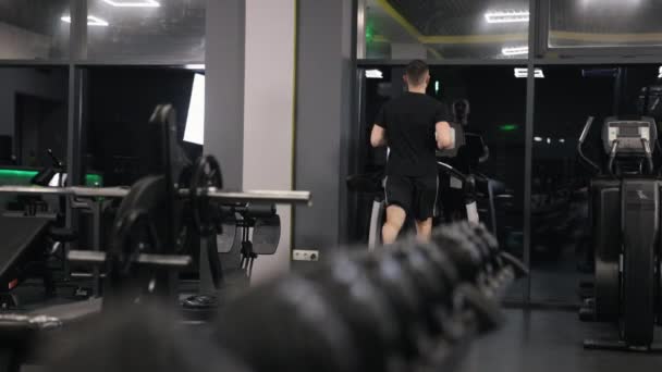 筋力トレーニング 心血管運動 ランニングルーチン 男は耐久性を向上させるためにトレッドミルで走っています — ストック動画