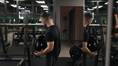 Spor salonu, ağırlık plakaları, beden eğitimi. İnsanoğlu halterine ağırlık verirken görülüyor. Bu onun güç antrenmanının bir parçası..