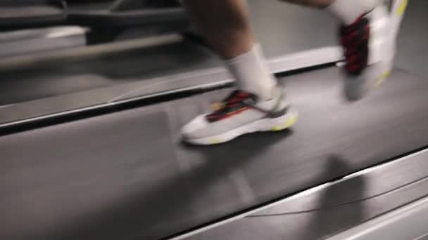 ランニングワークアウト アスレティックトレーニング 脚の筋肉 ジムでのカーディオトレーニング中にトレッドミルで走っていると 人の足が近くに表示されます — ストック動画