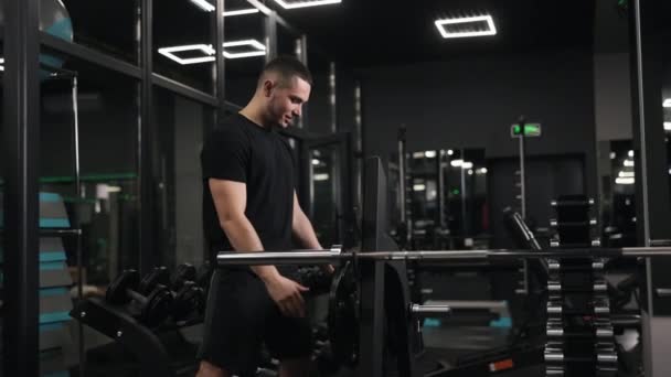 力量训练 重量板 体能训练 在健身房 男人把重量装到杠铃上 — 图库视频影像