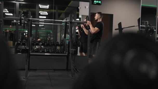 ジム機器 フィットネス献身 トレーニング強度 ジムの設定では 男は彼の鐘の重さを増加表示されます — ストック動画