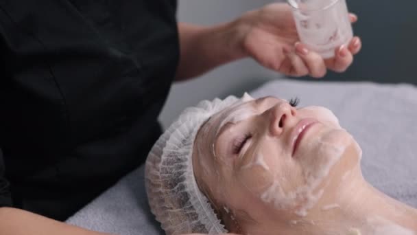 顔のブラシ 女性の顔 酵素マスク 現代化粧品の酵素マスクで美容剥離手順 レチノール処理で顔のブラシの皮 女性の皮膚の剥離手順 — ストック動画
