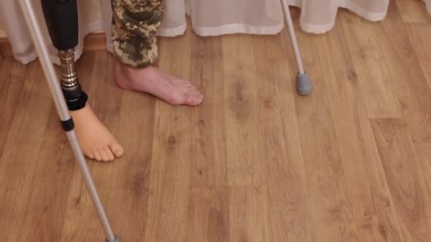 負傷した戦士 軍のリハビリテーション 戦争の傷 義肢と松葉杖を持った障害者の退役軍人が部屋の周りを歩いているのを至近距離から撮影しました — ストック動画