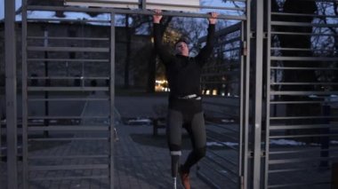 Protez bacak, spor performansı, spor motivasyonu. Akşamları protez bacaklı bir adam spor sahasında barfiks çekerek spora katılıyor..