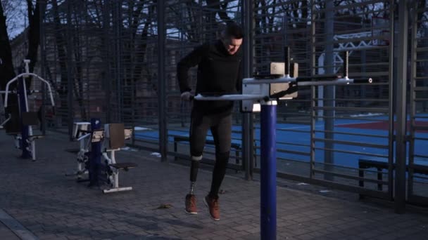 Sportplatz Beinprothese Bewegungsroutine Sportplatz Ein Mann Mit Beinprothese Klimmzüge Barren — Stockvideo