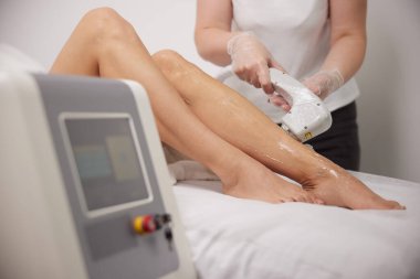 Tıbbi lazer, epilasyon makinesi, lazer epilasyonu. Kadınların bacaklarında saç kesimi, epilasyon ve kozmetoloji, saç aldırma kozmetoloji prosedürü, kozmetoloji ve kozmetik bilimi ile spa konsepti