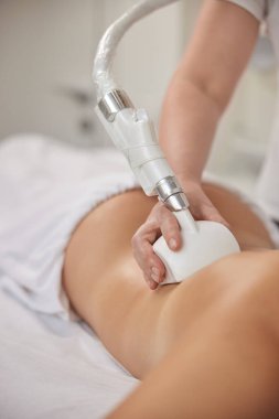 Lenfatik drenaj, selülit tedavisi, profesyonel masör. Çekici genç kadın güzellik hizmetlerine katılıyor, vücut şekillendirme, elektrikli süpürge masajları. Müşterilere figür düzeltmesi öneriliyor