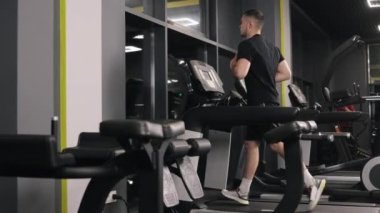 Kardiyovasküler egzersiz, spor aletleri, koşu bandı hızı. Adam egzersiz rejimi için koşu bandı kullanıyor..