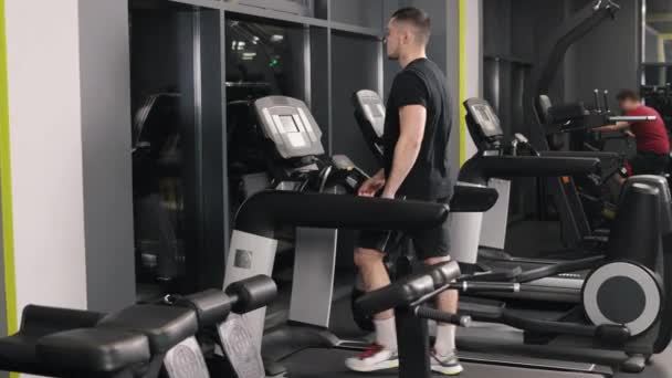 男人运动 有氧运动 这个年轻人正在跑步机上的体育馆里锻炼 — 图库视频影像