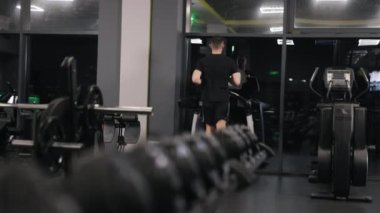 Sağlık sigortası, kişisel eğitim, spor salonu koşu bandı. Jimnastiğe giden kişi spor salonunun seviyesini yükseltmek için koşu bandı kullanıyor..