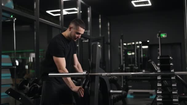무거운 무거운 들어올리기 사람은 체육관에서 몸무게 접시를 부착하는 을묘사 — 비디오