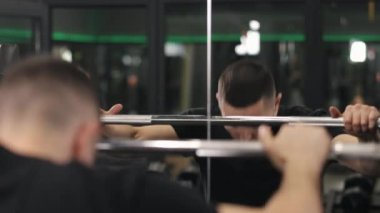 Spor konsepti, uygun form, çömelme yarışmaları. Gergin halterlerle boğuşan vücut geliştirici güçlü bir erkeksi enerji ve sağlıklı bir yaşam tarzı sergiliyor.