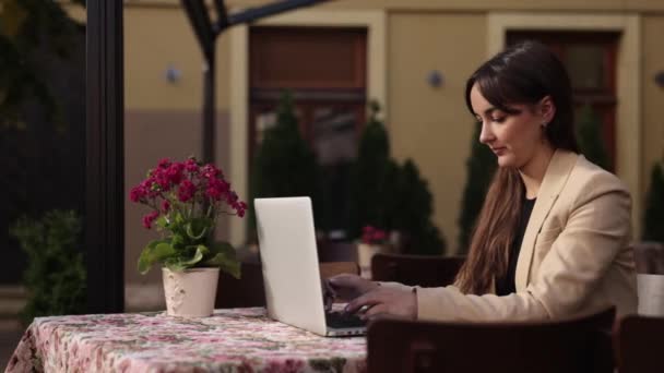 女性の仕事 ビジネス女性の入力 ノートパソコンを使用して スタイリッシュなブルネットの女性は太陽の光で外のラップトップコンピュータに入力し キーボードで作業し 彼女のラップトップで作業し 電子メールを入力 — ストック動画