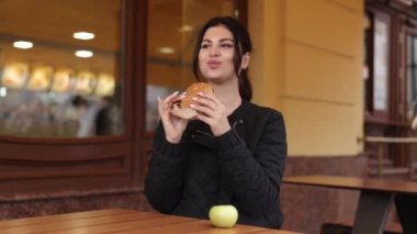 Sağlıksız seçim, dengesiz diyet, fast food bağımlılığı. Kadın sağlıklı elma yemek yerine hamburgerle şımarmaya karar veriyor..