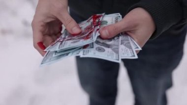 Yasadışı kazançlar, suç zenginliği, nakit saymak. Bir adamın elleri kana bulanmış dolarları hesaplar..