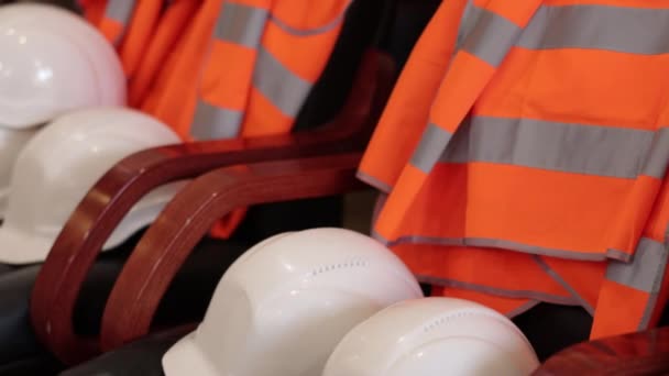 安全规程 个人防护 防护服 在工厂 工人们将白色工程头盔和橙色信号背心组织起来等待使用 — 图库视频影像