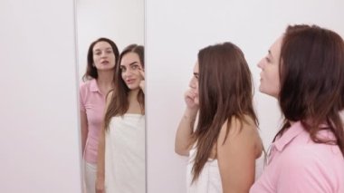 Yüz analizi, müşteri iletişimi, müşteri değerlendirmesi. Aynayı kullanarak, kadın müşteri güzellik uzmanına yüzündeki çözülmesi gereken sorunları gösterir..