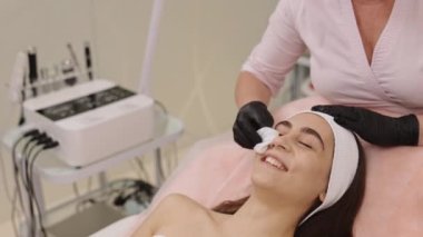Yüz bakımı, güzellik hizmeti, müşteri şımartma. Kişilerin yüzünü temizlemek için, profesyonel cilt temizleyiciye batırılmış peçeteleri dikkatlice ciltteki kirlilikleri temizlemek için kullanır..