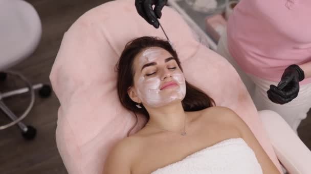 Tratamiento Facial Crema Blanca Rejuvenecimiento Facial Cosmetólogo Emplea Una Espátula — Vídeos de Stock