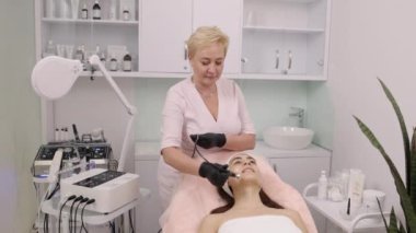 Kaldırma tedavisi, cerrahi olmayan yüz gerdirme, müşteri ifadeleri. Güzellik uzmanı, radyo frekans kaldırma olarak da adlandırılan RF kaldırma içeren hasta tedavisi uyguluyor..