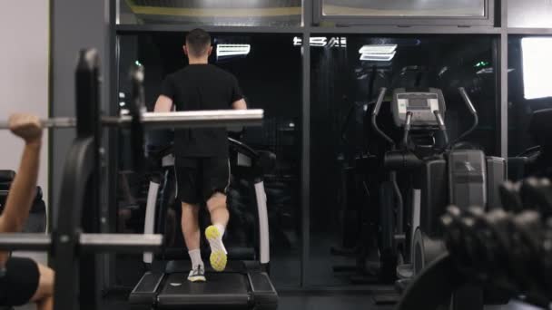 健身动机 健身追踪器 这个年轻人在跑步机上做心血管运动 — 图库视频影像